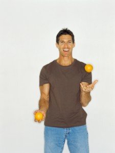 man juggling oranges
